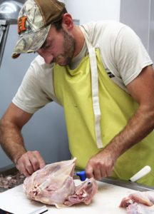 Jared McCool processes a chicken