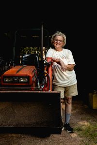 Peggy Ahlberg standing next to tractor