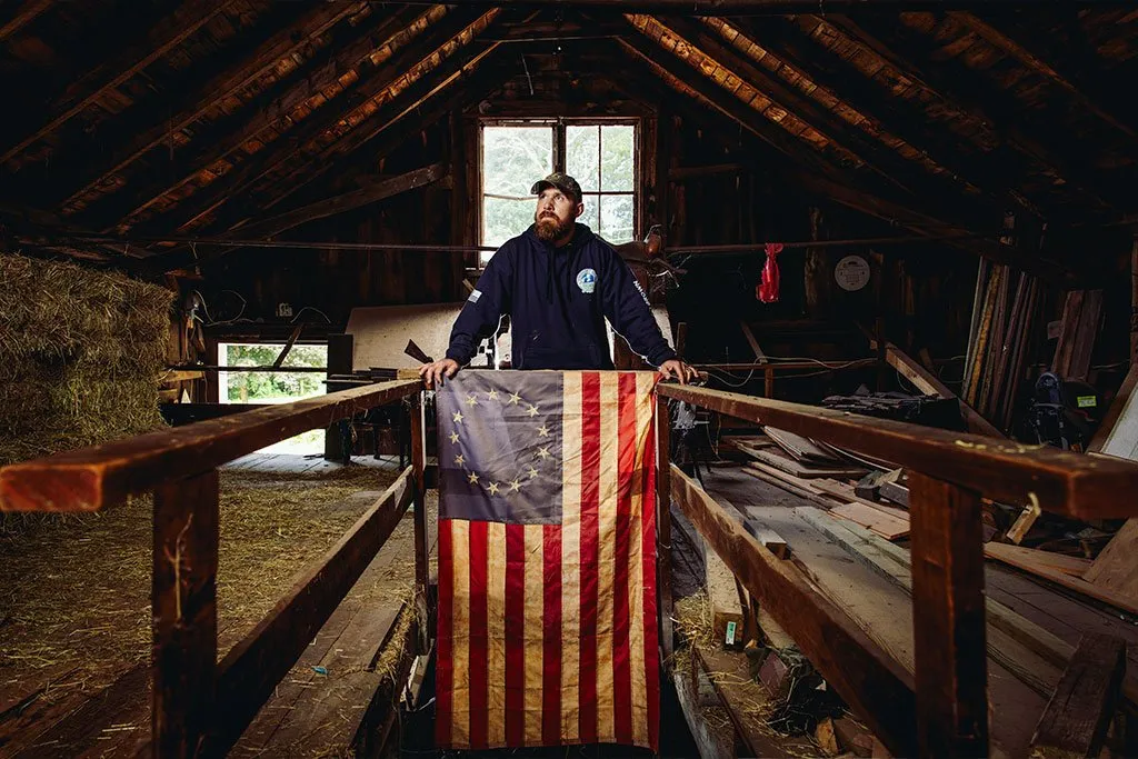 Ryan Sullivan with American flag in barn loft